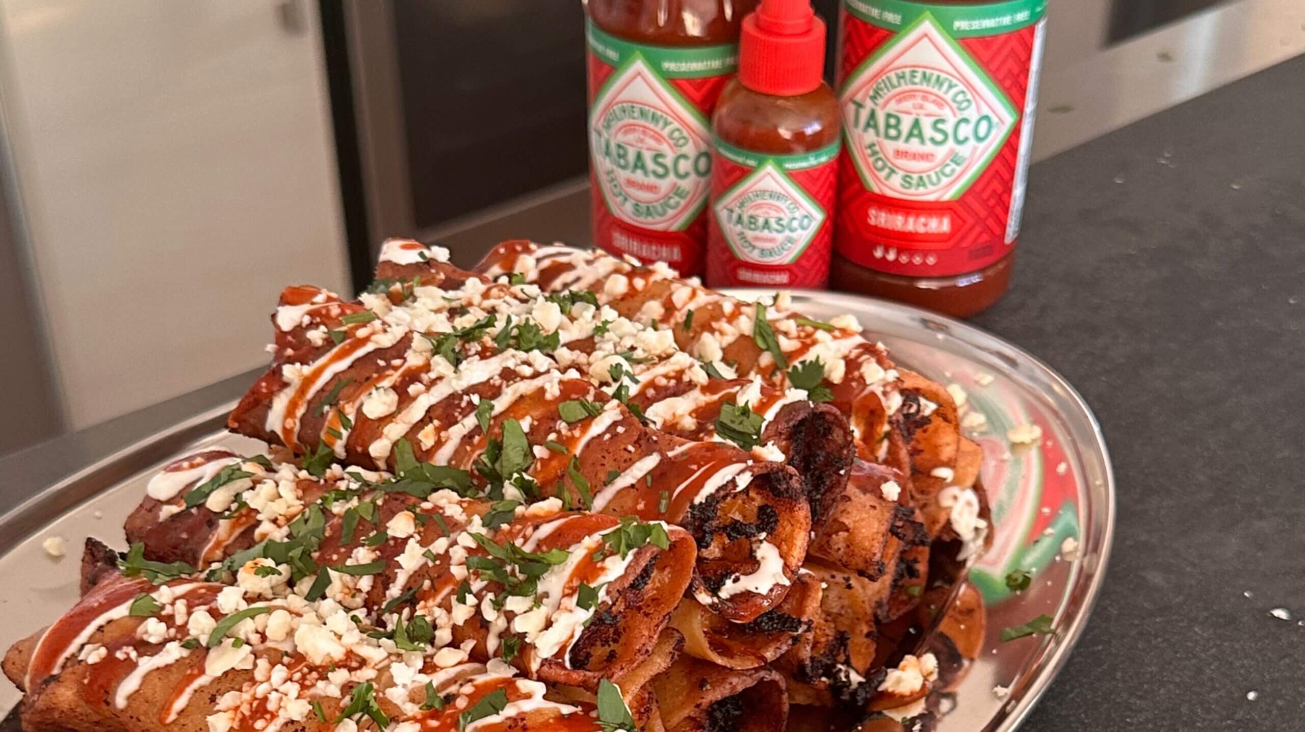 Crispy Chicken Taquitos and Queso spiced with TABASCO® Sriracha Sauce